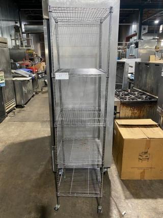 Tall metal storage rack with five wire shelves, number tag "47" attached. Used condition, suitable for industrial use.
