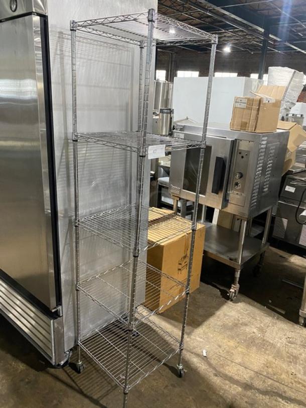 Five-tier metal shelving unit on wheels, industrial setting, excellent condition. Tag indicates model details and pricing.
