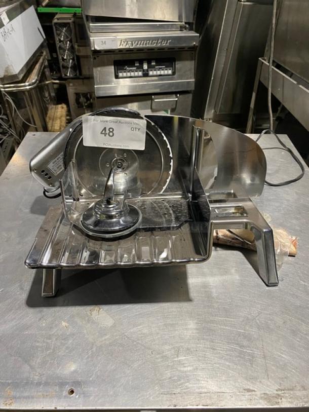 Commercial meat slicer on stainless steel surface. Label reads "48 PRX Auctions". Appears in good condition.