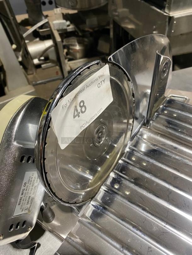 Commercial meat slicer with stainless steel blade and body. Label marked "48" and "PCI Auctions." Good condition.