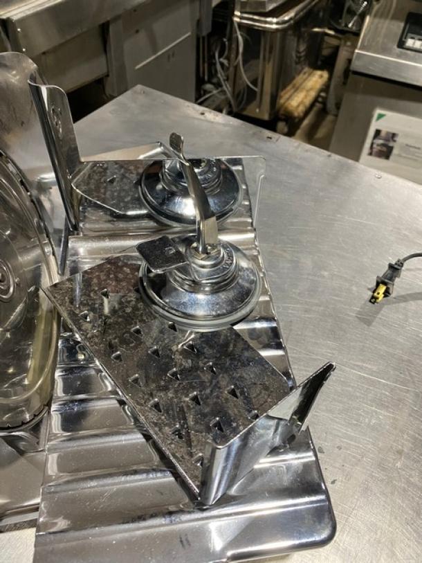 Stainless steel condiment pump station with dual dispensers, suitable for commercial use. Polished surface, in good condition.