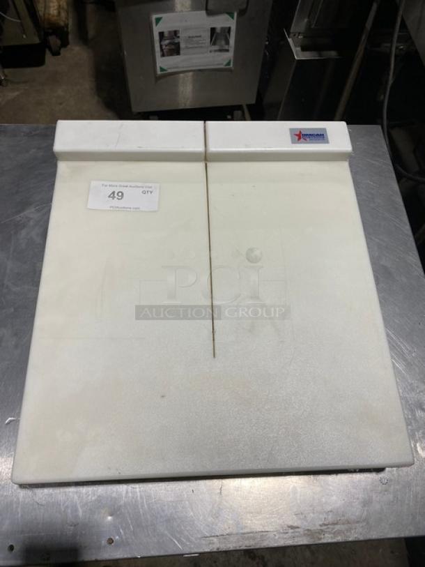 White plastic cutting board by Nemco, with visible wear and a center groove. Auction label reads "49."