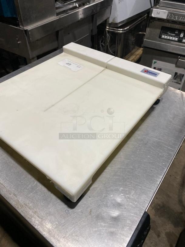 Commercial cutting board with juice groove, white, used condition, on metal surface; inspection tag and brand label visible.