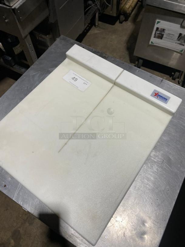 White plastic cutting board with groove and branding label, showing light wear, on stainless steel surface. Marked "A9".