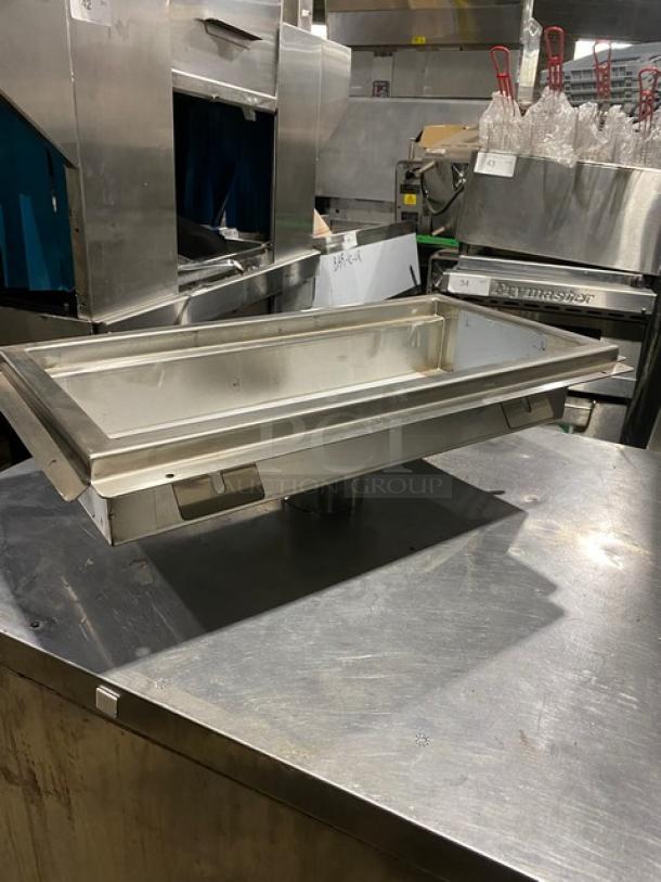 Stainless steel buffet serving tray with stand, rectangular shape, industrial kitchen setting, good condition, no visible markings.
