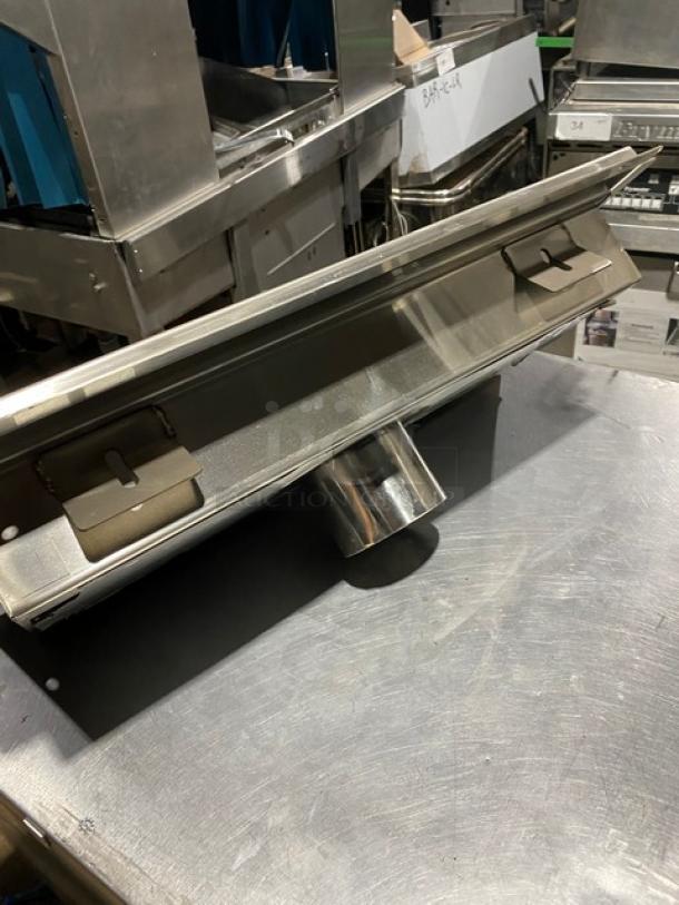 Stainless steel industrial drain funnel, rectangular design, with a central cylindrical outlet. Appears in good condition.