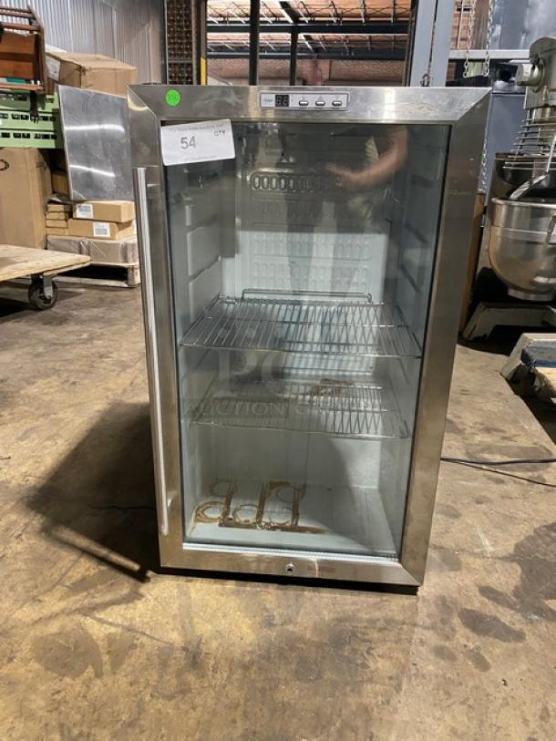 Silver mini fridge with glass door, two wire shelves, and visible rust. Unit number 54 displayed on a label. Used condition.