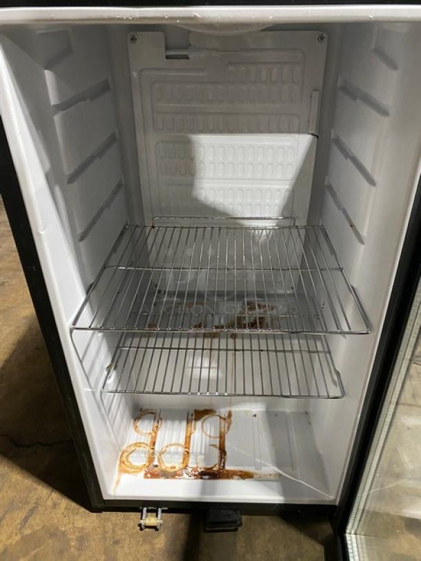 Open mini fridge with stainless steel shelves, noticeable stains on the bottom. Needs cleaning, otherwise appears intact.
