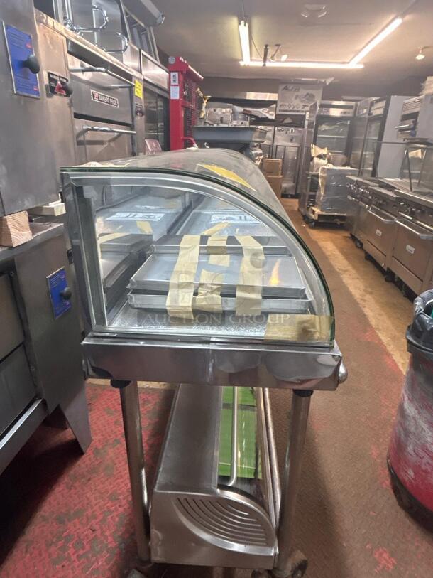 Commercial refrigerated display case, curved glass, stainless steel, multiple trays, fair condition. Suitable for deli use.