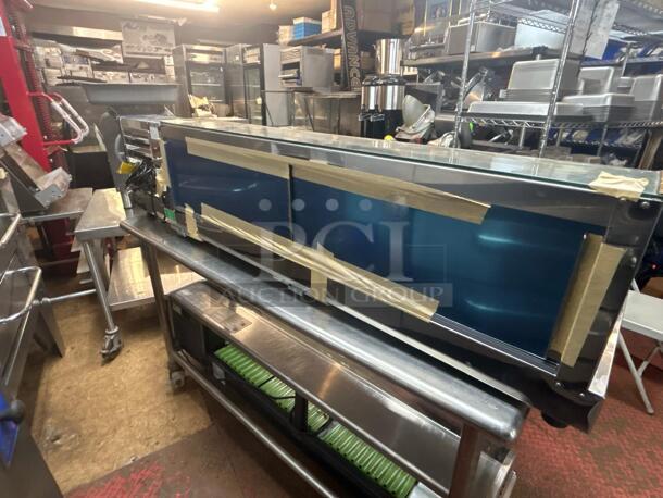 Stainless steel commercial refrigerated display case, blue interior, taped for protection, on wheels, excellent condition.