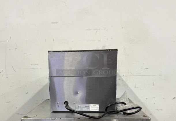 Stainless steel kitchen appliance with power cord, model GS-03, in good condition. Label indicates compliance info.