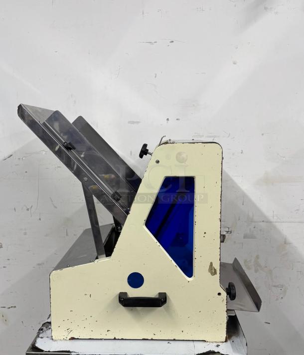 Industrial paper folding machine, used condition, visible wear, features a metal frame and blue tinted panel.