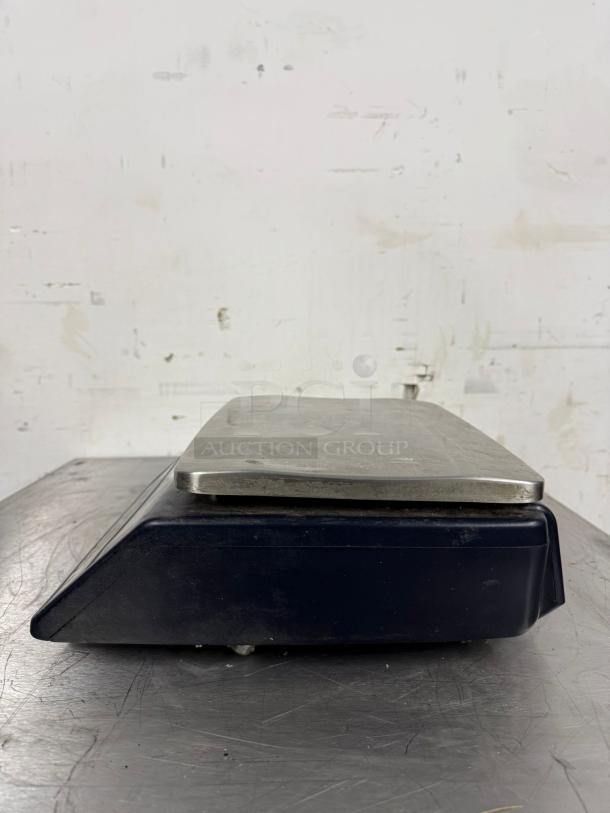 Vintage metal scale with a black base. Some wear and scratches visible. No markings or labels present.