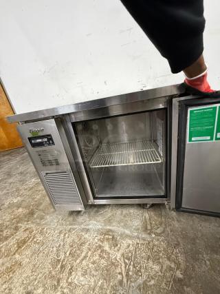 Stainless steel undercounter refrigerator, single door, visible wire shelf, digital temperature display, well-maintained.