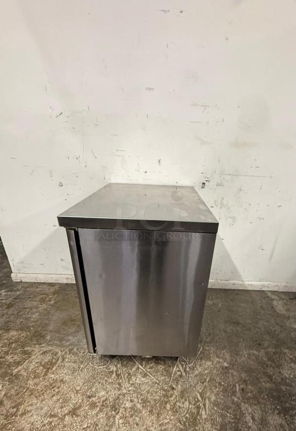 Stainless steel commercial refrigerator, single door, used condition, visible surface marks, no labels or tags.
