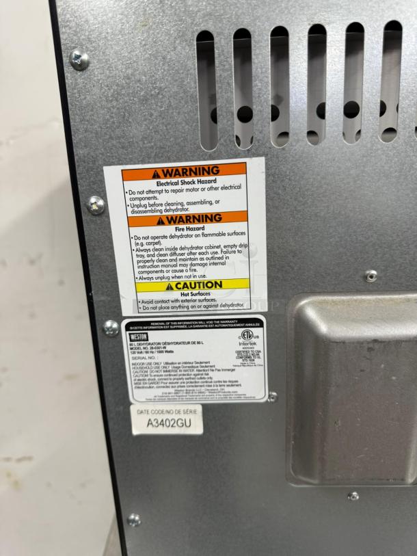 Weston dehydrator back panel with warning labels. Model 28-0501-W, serial A3402GU. Provides safety and usage instructions.