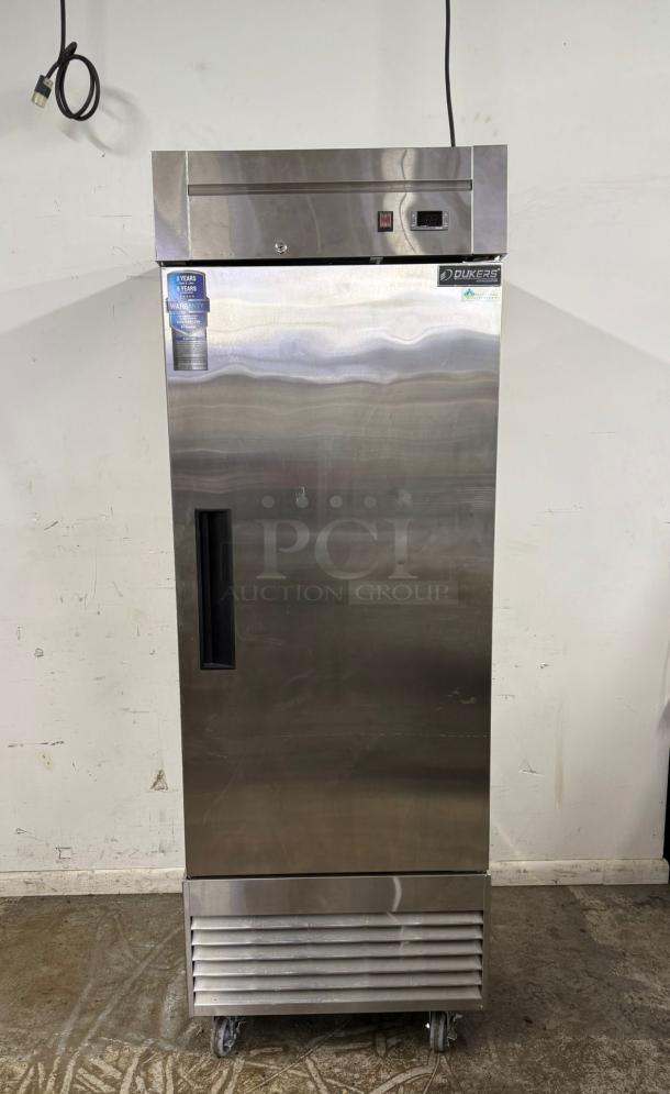 Dukers stainless steel commercial refrigerator with digital display, lock, and wheels. Warranty tag visible. Excellent condition.