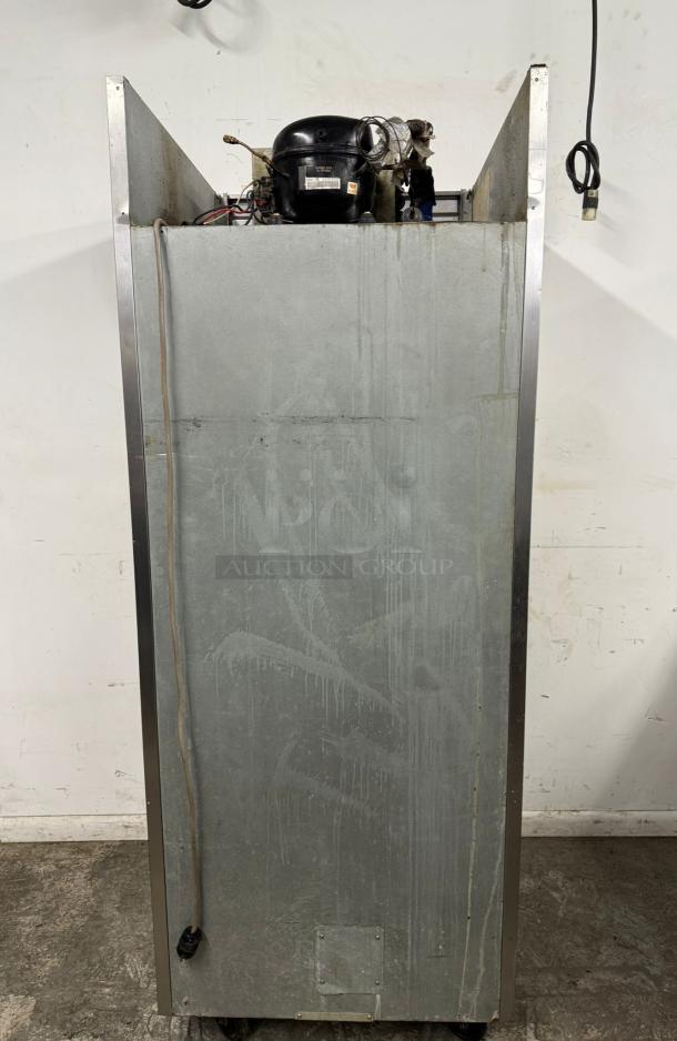 Industrial refrigeration unit with visible compressor, metal casing, showing wear. Ideal for commercial use. Includes power cord.