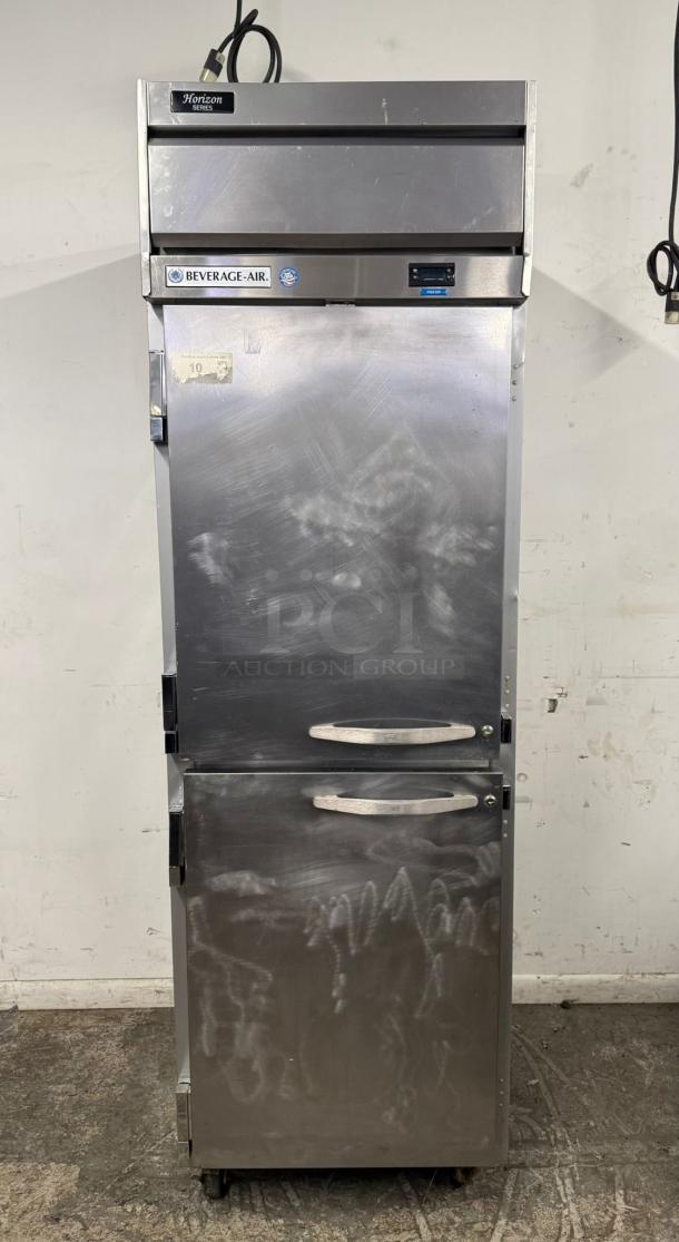 Beverage-Air Horizon Series commercial refrigerator, stainless steel, dual doors, used condition with visible markings, wheels for mobility.