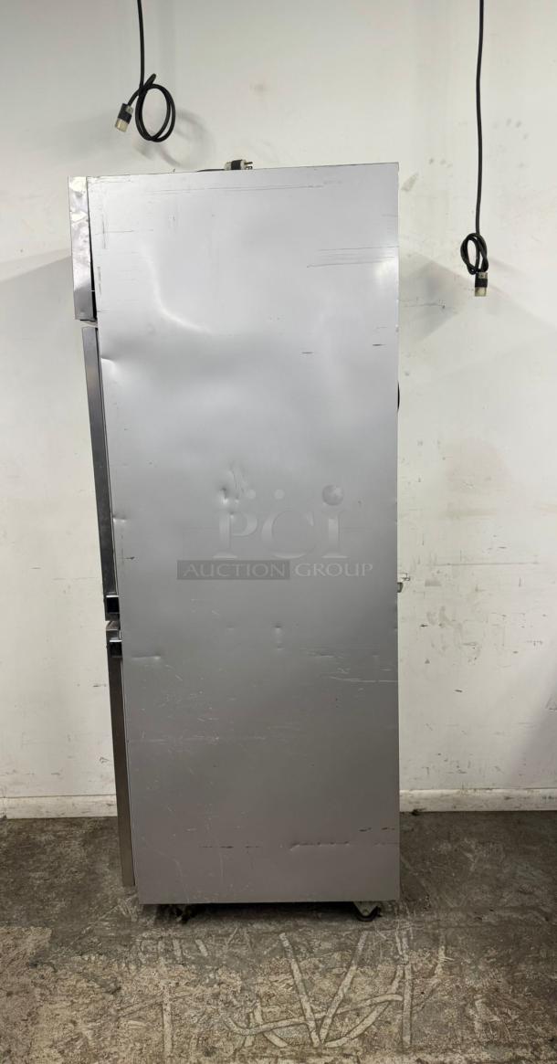 Large silver metal storage cabinet on wheels, visible dents and scratches, used condition, no visible branding or tags.