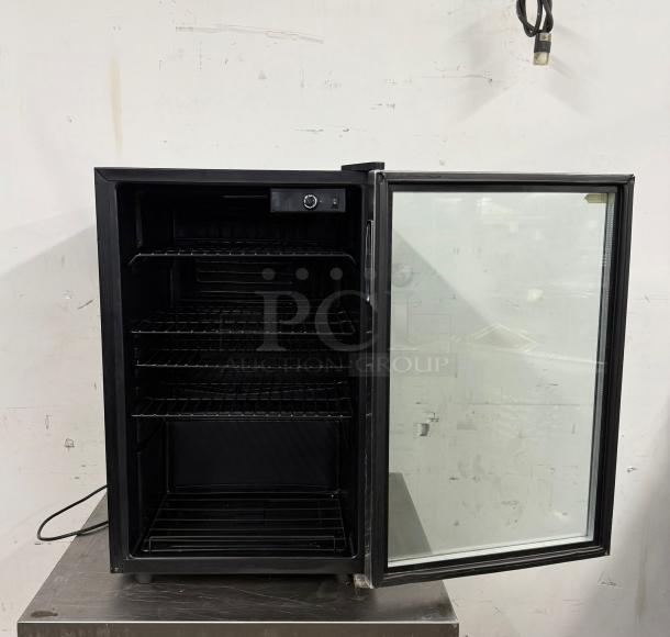 Black glass-door mini fridge with adjustable shelves, temperature control knob, lightly worn exterior. Ideal for compact spaces.