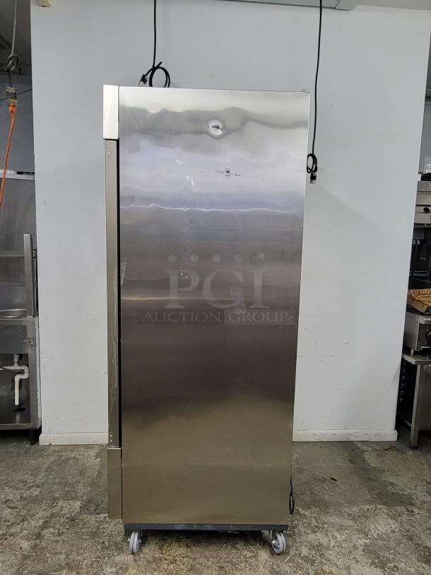 Commercial stainless steel refrigerator, single door, on casters, minor surface scratches, no visible brand or labels.