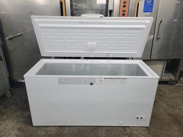White chest freezer with open lid, spacious interior, temperature controls, and safety lock. Good condition, suitable for storage.