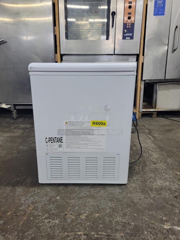 White chest freezer with R600a refrigerant label, warning instructions, and C-Pentane marking. Good condition.