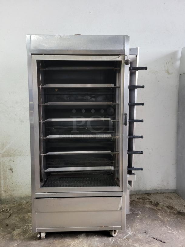 Commercial stainless steel oven with multiple racks and visible knobs on the side. Used condition with casters.