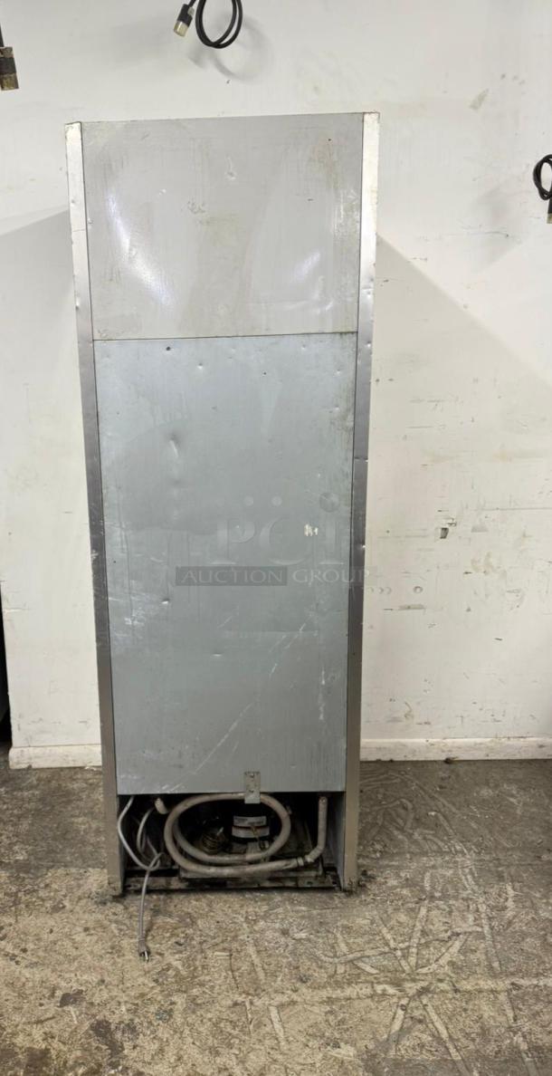 Commercial refrigerator back view, metal casing with visible wear and scratches, exposed coils and wiring at the base. Ideal for refurbishment.