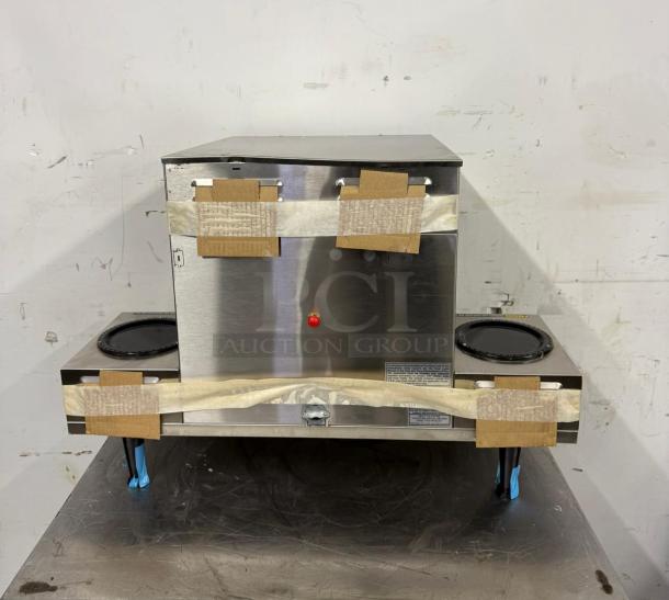 Stainless steel commercial dual-burner stovetop, new condition, protective packaging intact, manufacturer label on front.