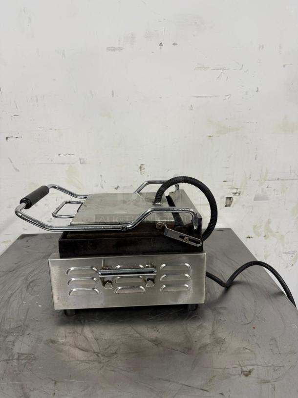 Commercial electric panini press, stainless steel, heavy-duty, with vented front panel and power cord. Used condition.