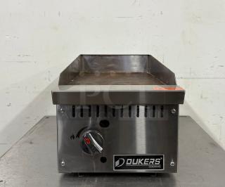 Dukers countertop griddle, stainless steel, manual control knob. Used condition, visible wear on cooking surface.
