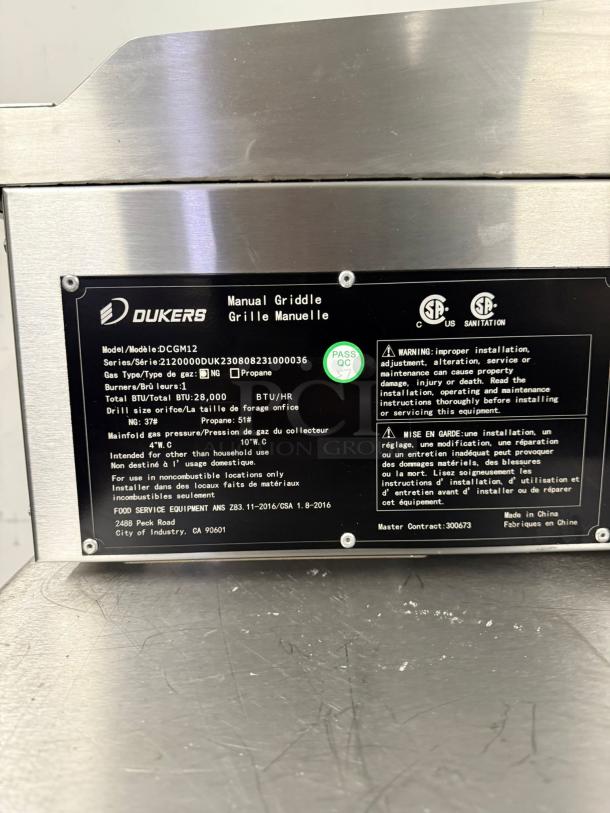 Dukers manual griddle, model DCGM12, stainless steel, natural gas/propane, 28,000 BTU, CSA certified, QC pass, made in China.