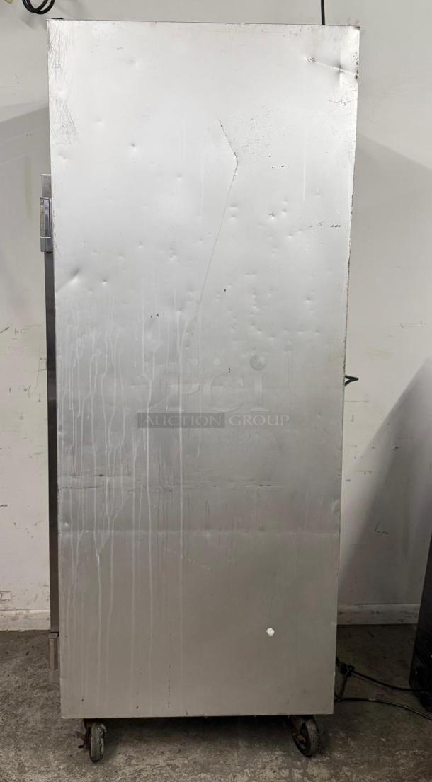 Industrial metal storage cabinet with wheels, showing surface scratches and dents. No visible labels or markings.