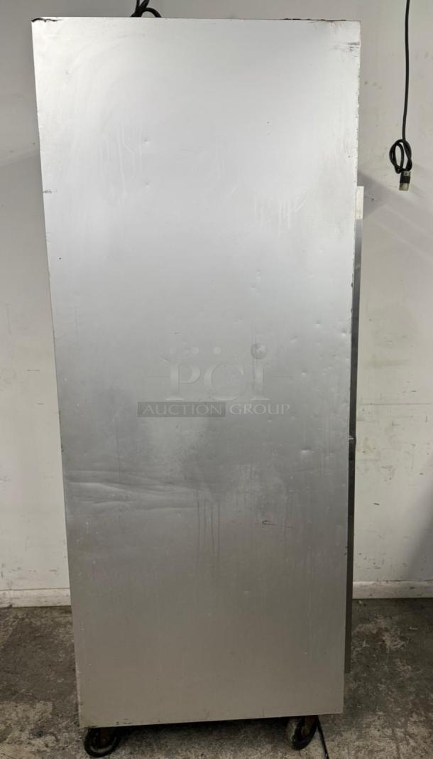 Tall metal storage cabinet on casters, showing signs of wear and surface scratches. No visible tags or labels.