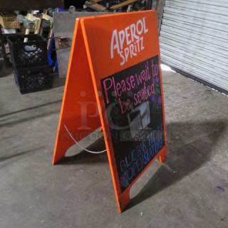 A-Frame sidewalk chalkboard sign, 24x39 inches, orange frame, "Aperol Spritz" branding, reads "Please wait to be seated."