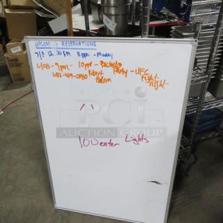 24x36 dry erase board with a metallic frame, notes written in colored markers, used condition.
