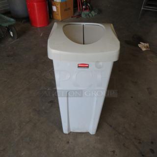 Rubbermaid trash can with hinged lid, gray, durable plastic, used condition, feature: swinging lid, branded label visible.