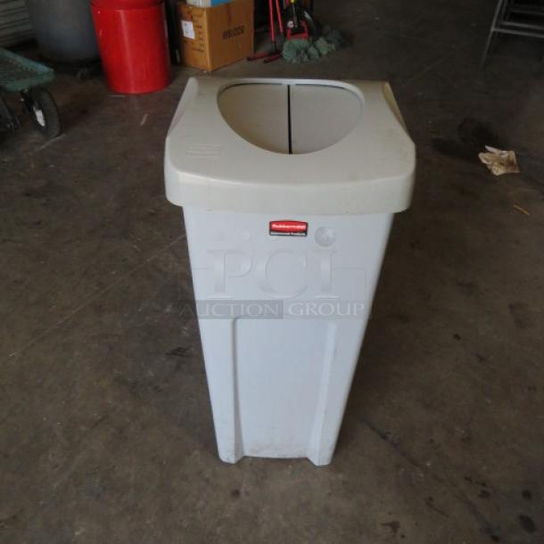 Rubbermaid trash can with hinged lid, gray, red Rubbermaid logo on front, good condition, ideal for waste management.