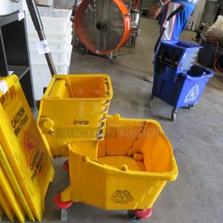 Yellow mop bucket with wringer, red casters, "Rubbermaid" logo, and "Caution Wet Floor" signage, in good used condition.