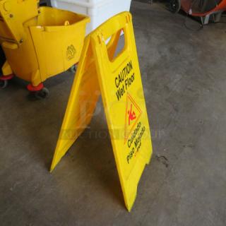 Yellow caution wet floor sign, double-sided, with bilingual text in English and Spanish. In good condition.