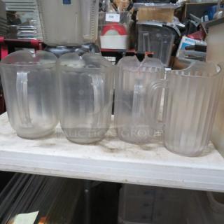 Four Poly Pitchers, model 4XBID, in frosted plastic, each with ergonomic handles, used condition, on a white surface.