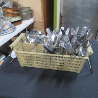 Plastic flatware dish rack filled with assorted silver flatware, including forks and spoons, on display.