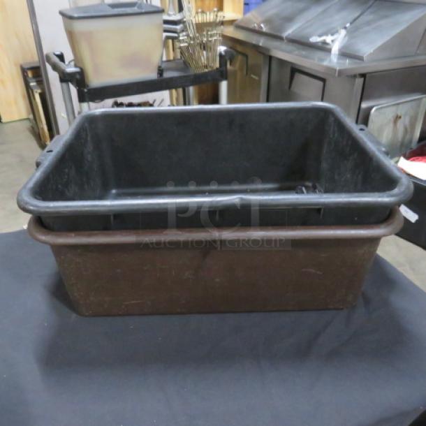 Black plastic bussing tub with sturdy handles, used for clearing dishes, in fair condition.