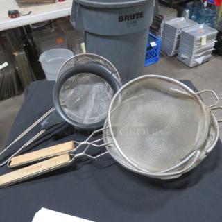 One lot of 4 assorted strainers with metal mesh and wooden handles, varying sizes, used condition. 