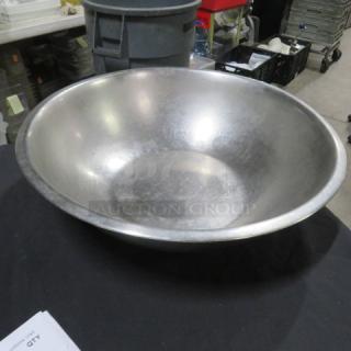 19-inch stainless steel mixing bowl in used condition on a table, showing light surface scratches.