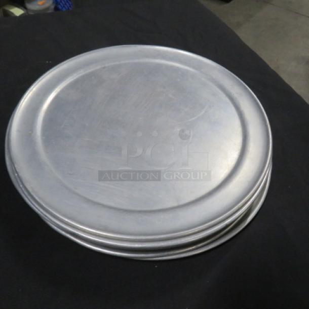 Set of five 10-inch pizza pans, aluminum, stacked, used condition, no visible markings, ideal for baking.
