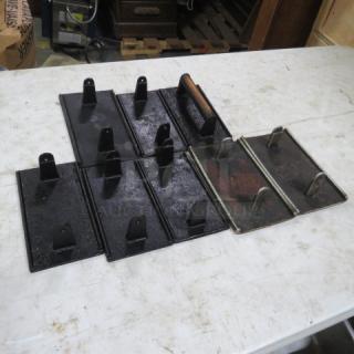 One lot of black cast iron steak weights with handles, showing signs of wear, suitable for grilling tasks.