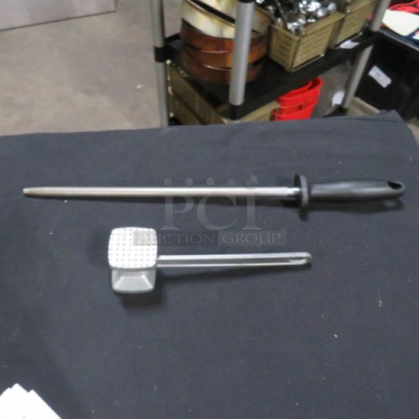 Assorted utensil set includes a meat mallet and honing steel with black handles, in good condition.